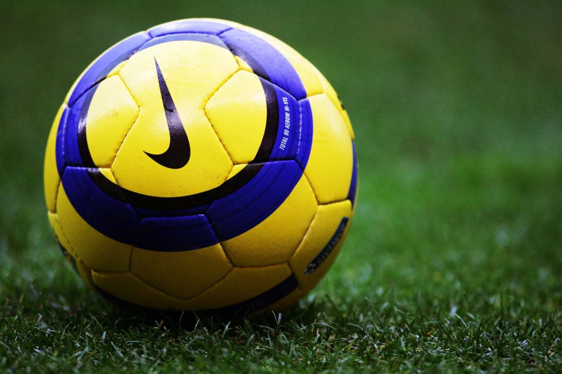 Close-up of a yellow and blue Nike soccer ball on a soccer field.